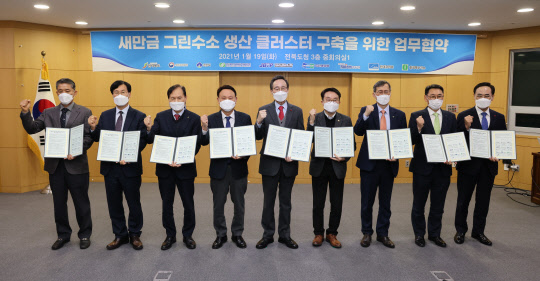 19일 전북도청에서 한국수력원자력, 전라북도, 새만금개발청, 군산시, 전북테크노파크, 현대로템, 두산중공업 등 9개 기관 관계자들이 '새만금 그린수소 생산 클러스터 구축' 협력을 위한 업무협약(MOU)을 체결한 뒤 기념촬영하고 있다. <한국수력원자력 제공>